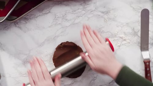 Hands Rolling Cookie Dough on Marble Countertop