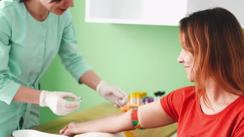 Medical Professional Drawing Blood From Patient in Clinic