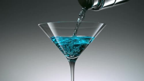 Pouring Bright Blue Liquid into Martini Glass