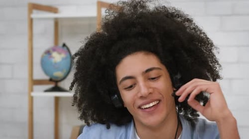 Young Adult with Headset Talking in Home Office