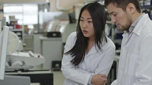Scientists Analyzing Data on Computer in Laboratory