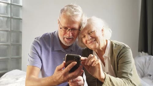 Happy Senior Couple Looking at Smartphone Together