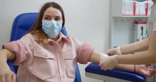 Woman Receiving Arm Bandage in Medical Clinic