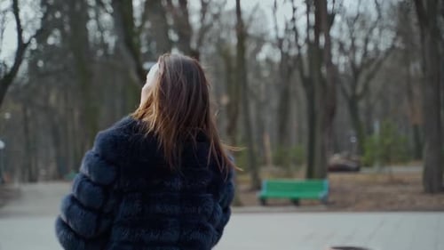Young woman in fur coat in the park