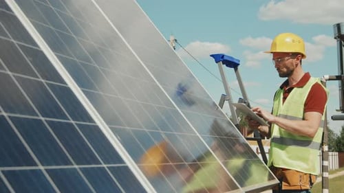 Engineer with Tablet Checking Solar Panels