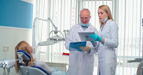 Dentists Discussing Treatment with Patient in Dental Office