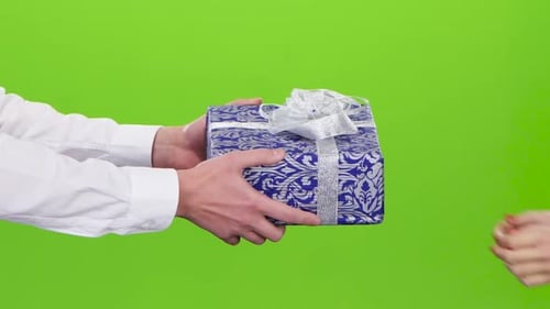 Hands Exchange a Wrapped Gift on Green Screen