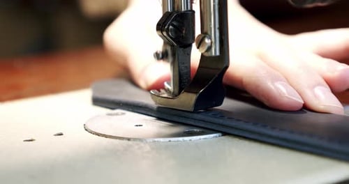 Leather being sewn using a sewing machine