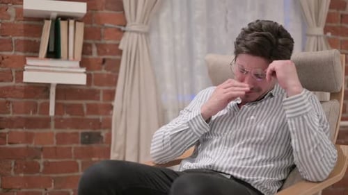 Distressed Man Crying in Rocking Chair