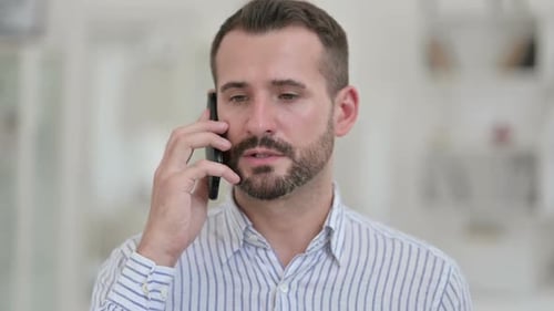 Portrait of Cheerful Young Man Talking on Smartphone