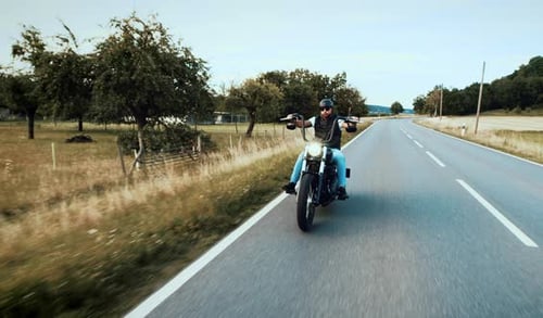 Man Riding Motorcycle on Country Road