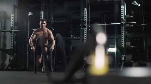 Healthy Lifestyle Athletic Man Performs Exercises with Battle Ropes Endurance Training in the Gym