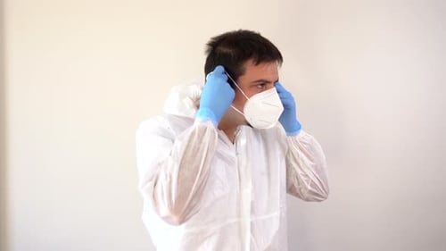 Adult Puts on Protective Medical Wear