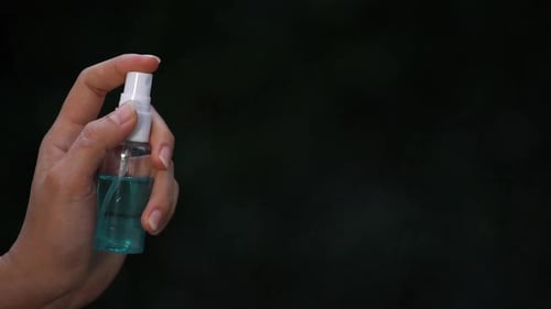 Zeitlupenbewegung der Hand mit Alkoholspray