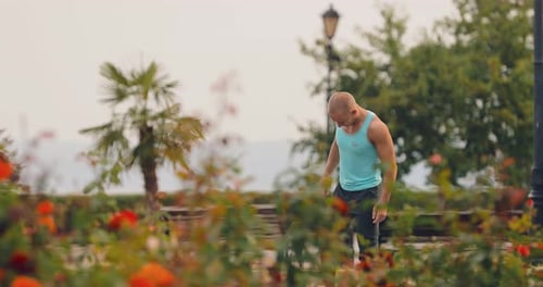 Muscular Man Stretching in a City Park