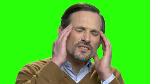 Man Rubbing Temples in Pain on Green Screen