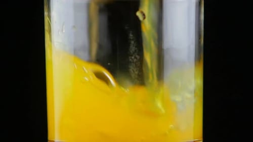 Orange Juice Pouring into Glass Close Up