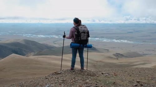 Jeune voyageuse ouvre les bras au sommet d'une montagne