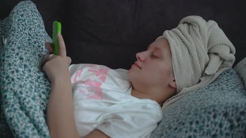 Young Adult Relaxing in Bed with Phone