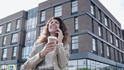 Smiling Woman Talking on Smartphone on City Street