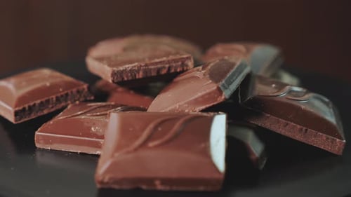 Pieces of Chocolate Bar on a Dark Background Rotate 360 Degrees Clockwise