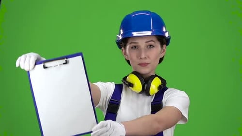 Builder in a Hard Hat and Safety Raises the Paper Plate . Green Screen. Close Up. Slow Motion