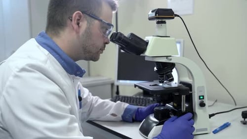 Scientist Uses Microscope in a Laboratory