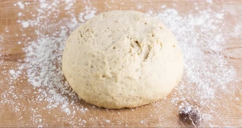 Pizza Dough Rising on a Wooden Cutting Board
