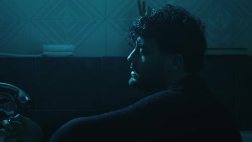 Contemplative Young Adult Sits in Dark Bathroom with Flame