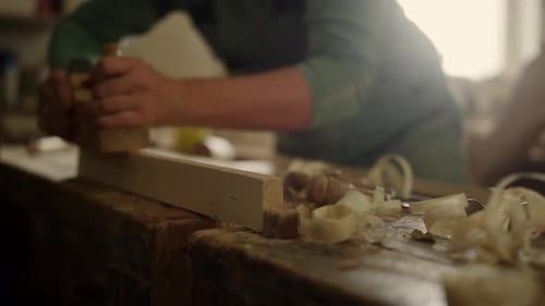 Unknown Carpenter Using Plane in Workshop