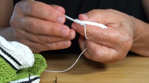 Hands Crocheting White Yarn into Intricate Pattern