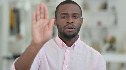Portrait d'un homme africain sérieux montrant le panneau d'arrêt à la main