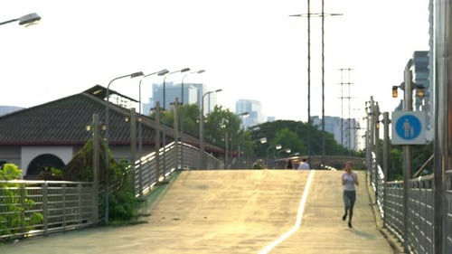 Woman Jogging on Elevated City Footbridge