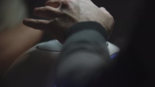Client de manucure masculin mettant ses mains sous une lampe ultraviolette