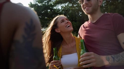 Friends Laughing and Drinking Beer in Summer Sunshine