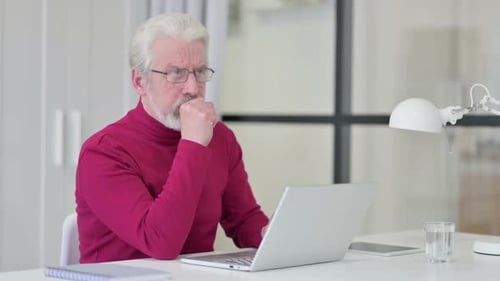 Mature Man Coughing While Using Laptop