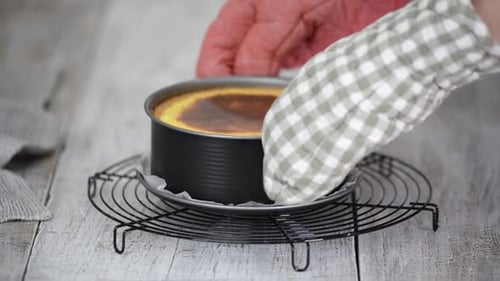 Freshly Baked Cheesecake being placed on a Rack
