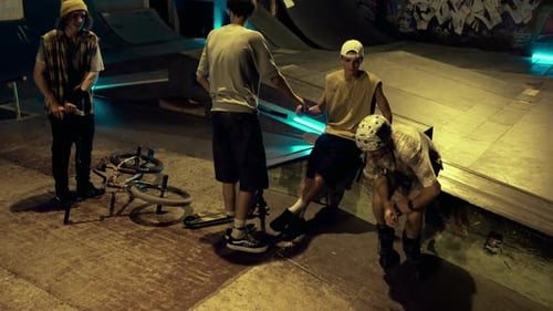 Young People Finishing Sport Training at Night Skate Park