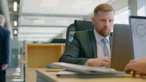 Businessman Working on Laptop at Office Desk