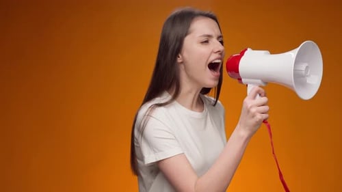 Woman Shouting into Megaphone on Orange Background