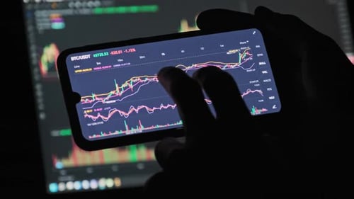 Hands View Cryptocurrency Data Graph on Phone