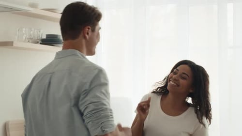 Smiling Woman Talking to Man in Bright Kitchen