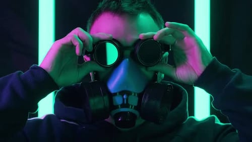 Man Wearing Respirator and Goggles in Futuristic Lighting