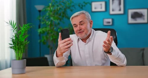 Man Video Calling on Smartphone From Home Office