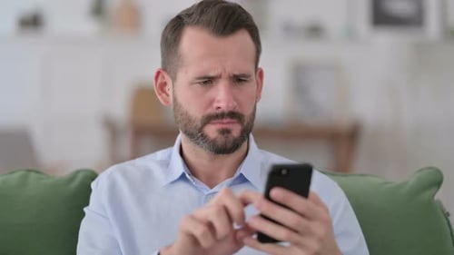 Man Cries While Using Smartphone in Home