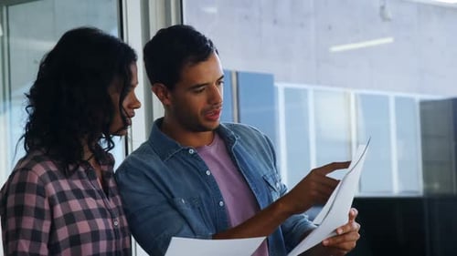 Coworkers Reviewing Documents Together Inside an Office