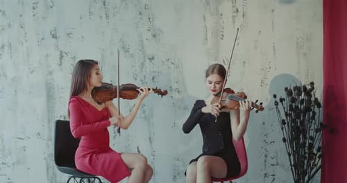 Elegant Women Playing Violins in a Studio