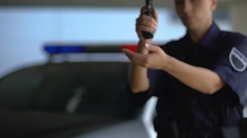 Police Officer Holding Gun Near Patrol Car
