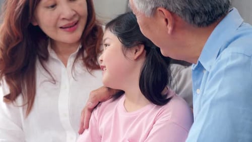 Grandparents Affectionately Smiling at Grandchild Indoors