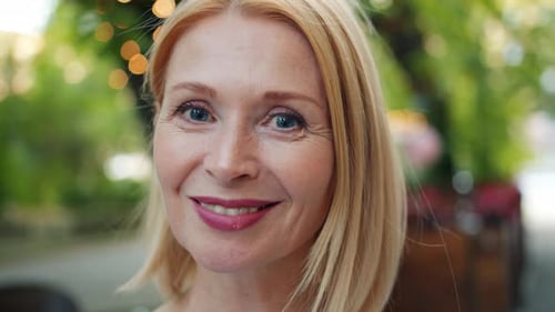 Close-up Portrait of Attractive Lady Looking at Camera Smiling Outdoors in City